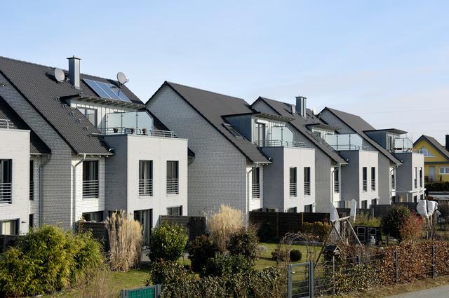 A row of modern terraced houses, with a solar panel on the roof of the house in the foreground